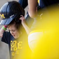 Natalie Harper puts on a helmet in the dugout on Saturday, May 4. Daniel Brenner I AnnArbor.com